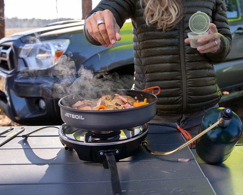 Sprinkling seasoning on cooked meat in the Jetboil HalfGen Cooking System Sprinkling seasoning on cooked meat in the Jetboil HalfGen Cooking System