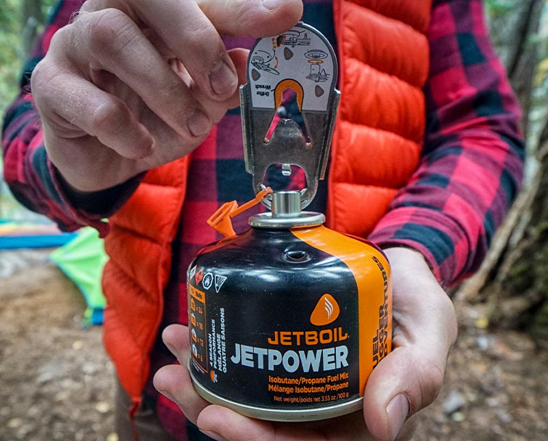 Holding Jetboil CrunchIt tool and JetPower Fuel