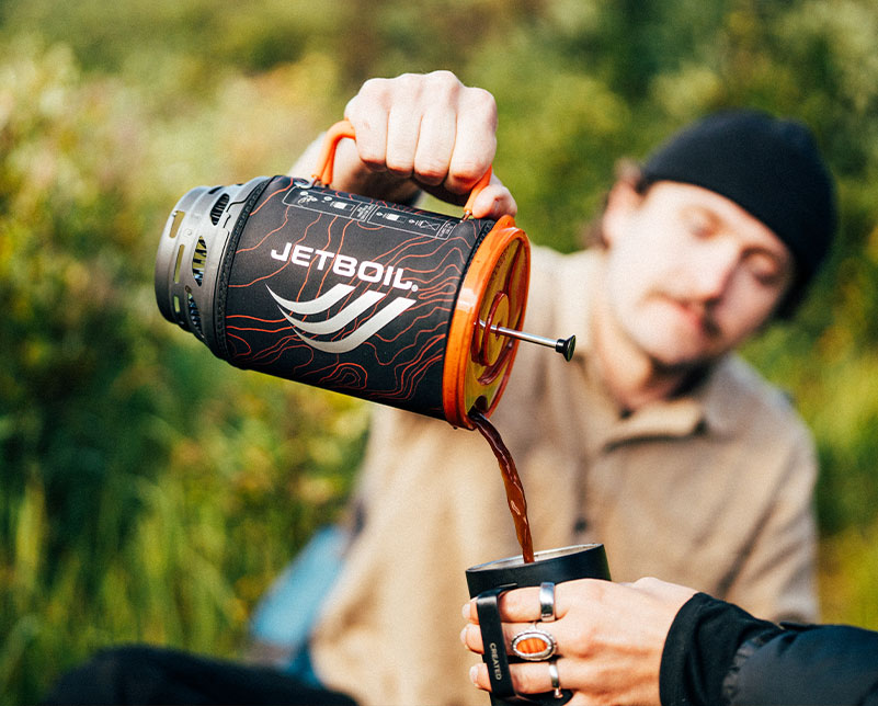 Pouring hot coffee from the Jetboil Flash Java 1.8L cooking system into a mug