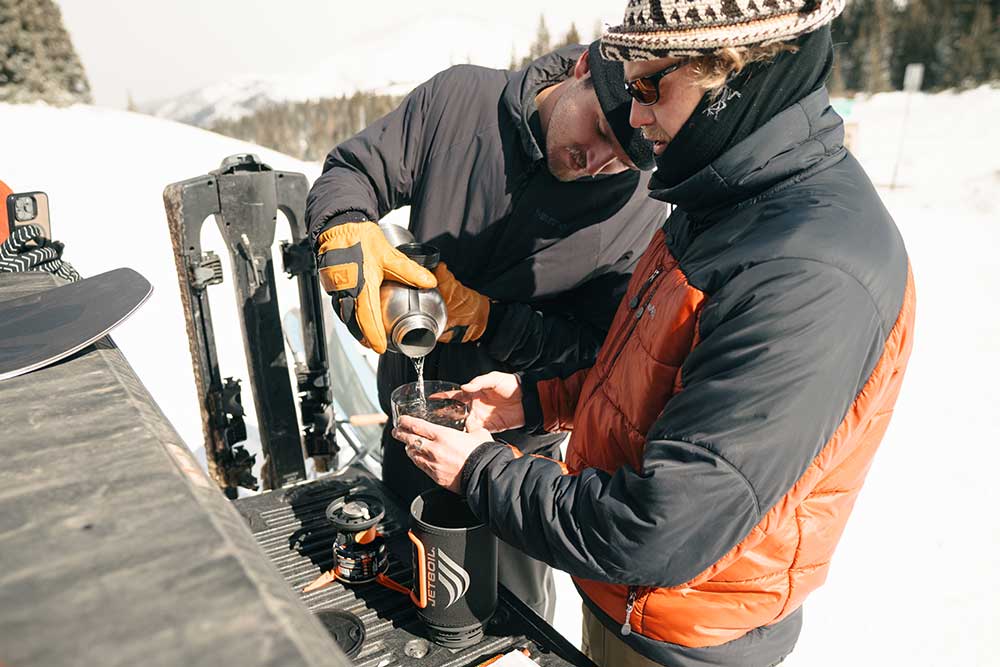 Man pouring water from stainless steel flash into Jetboil cooking system bottom cup 