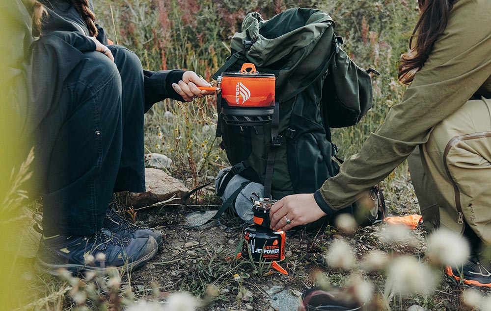 Holding the Jetboil TrailCook 1.2L Precision Cook System over burner while out on backpacking trip