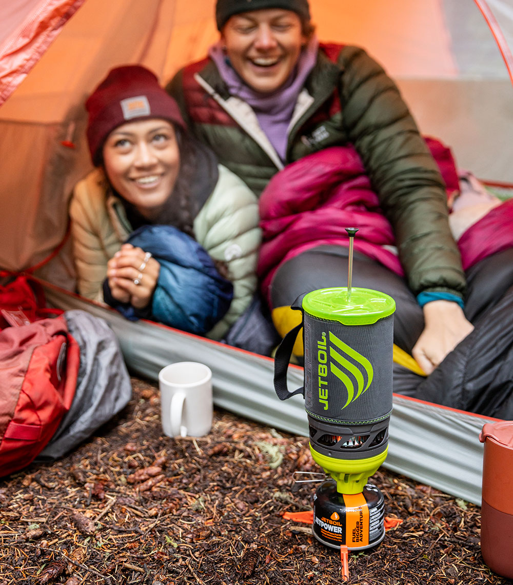 Two campers making coffee on a Jetboil Flash Java kit from their tent.