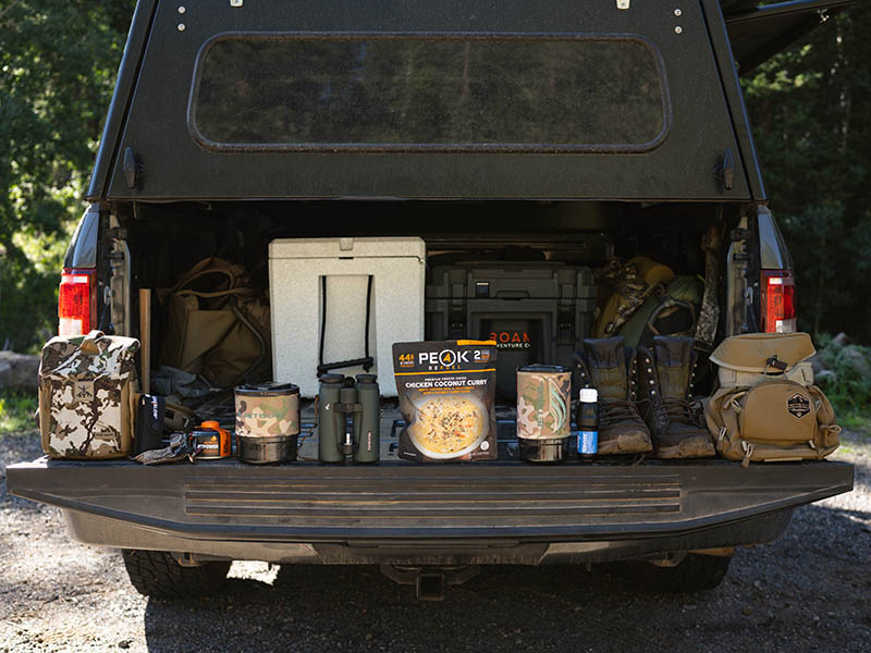 A cooking system laid out on the tailgate of a truck.