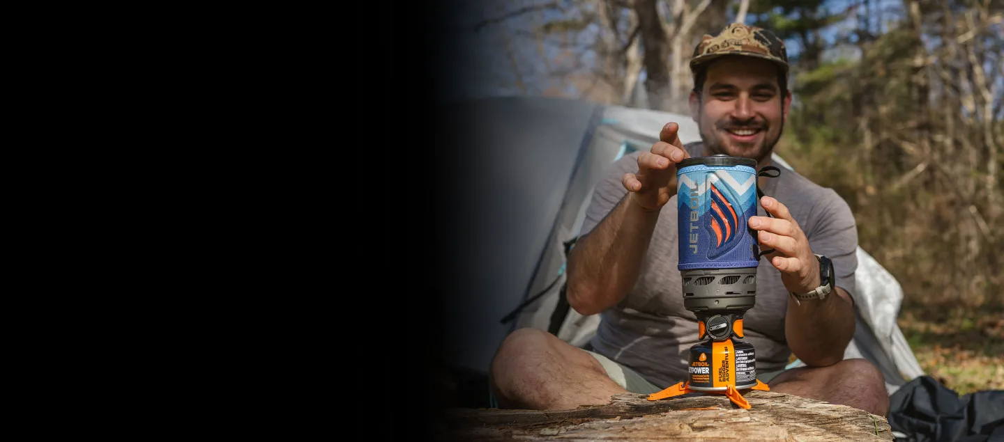 Smiling man reaching for the Jetboil Flash 1.0L Fast Boil System in the color Blue Mountain