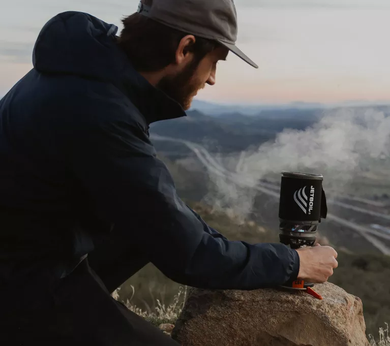 Man with Jetboil cooking system with steam flowing from top