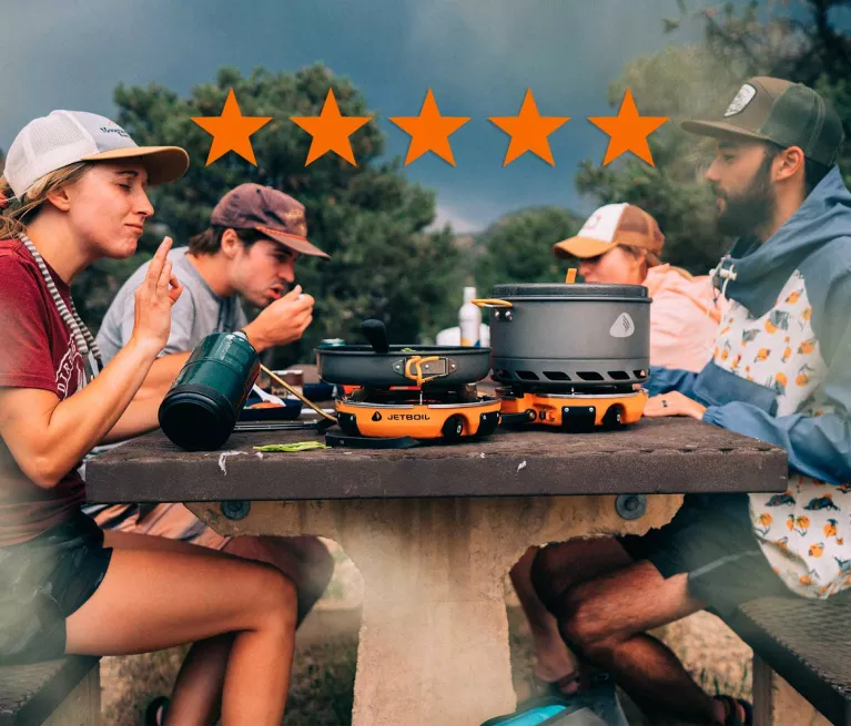 Group of friends enjoying a cooked meal in the Jetboil Genesis Basecamp System