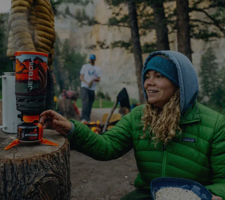 Smiling backpacker reaching for the Jetboil Flash 1.0L fast boil system