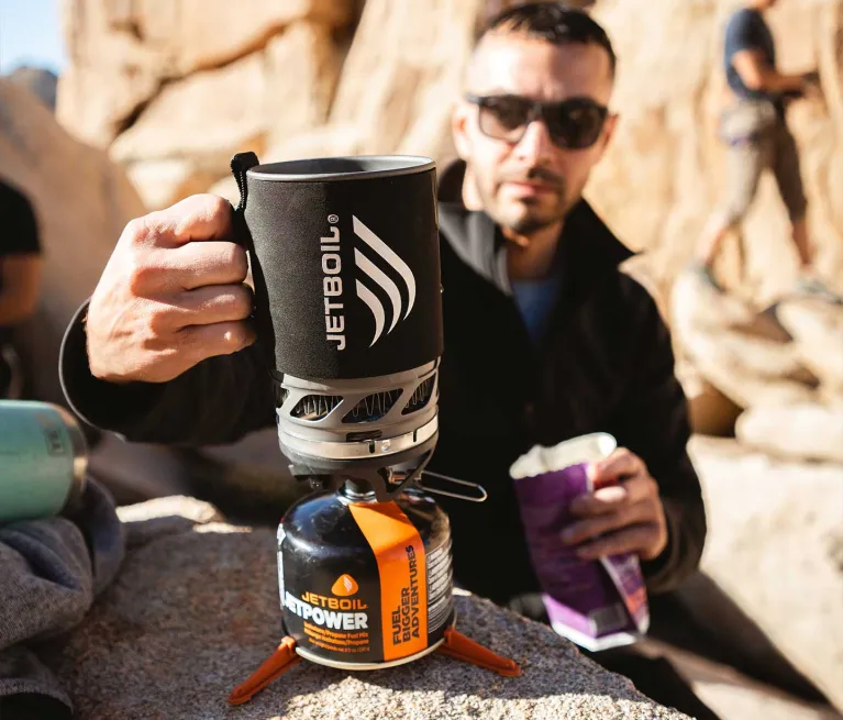 Holding handle of the Jetboil MicroMo precision cook system while waiting for water to boil