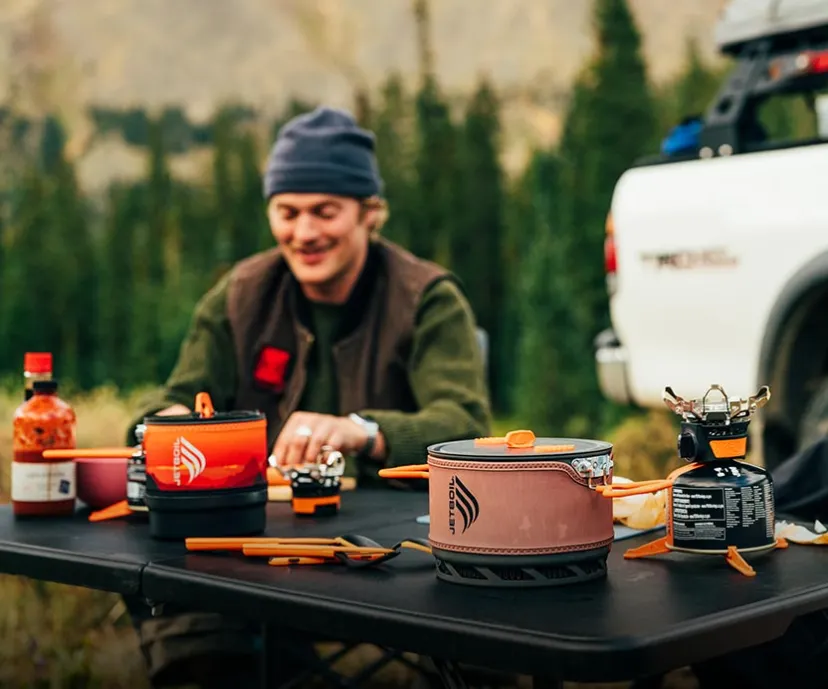 Man at camp table with Jetboil TrailCook 1.2L and 2.0L precision cook systems